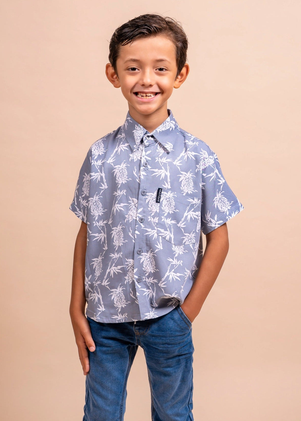 Boy wearing a grey polynesian shirt with pinaeple pattern
