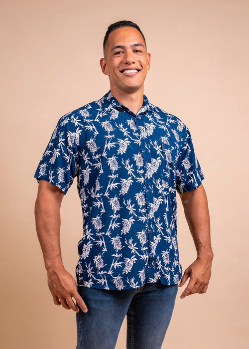 Man wearing a navy bleu polynesian shirt with pinaeple pattern 