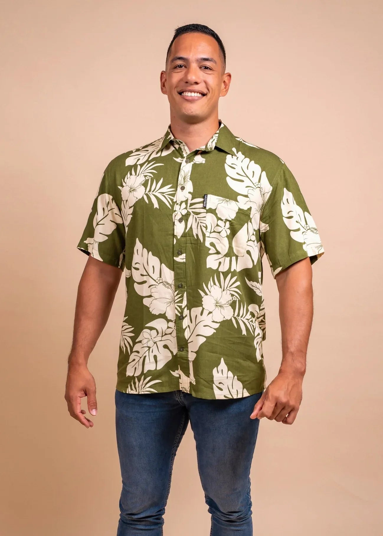 Man wearing a olive polynesian shirt with Hibiscus pattern 
