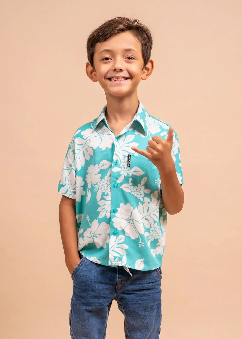 Boy wearing a light blue polynesian shirt with Flower pattern