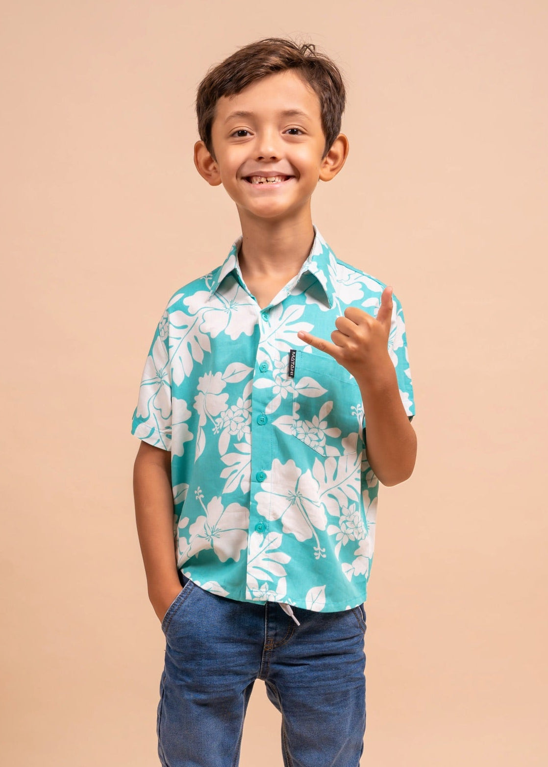 Boy wearing a light blue polynesian shirt with Flower pattern 