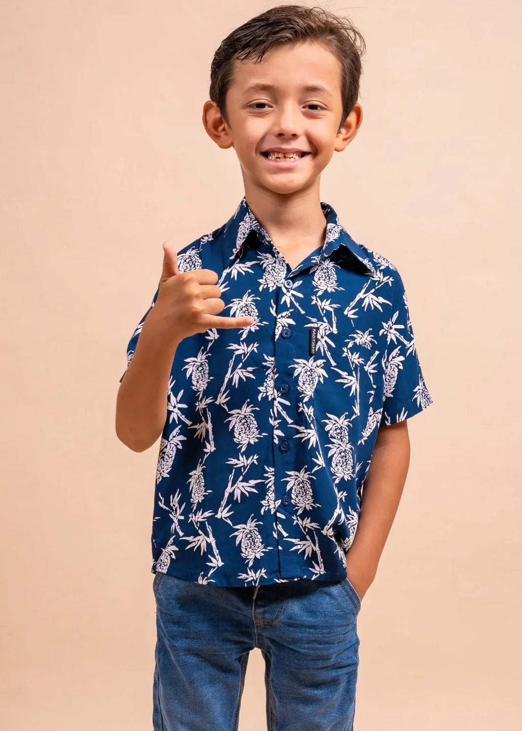 Boy wearing a bleu marine polynesian shirt with pinaeple pattern