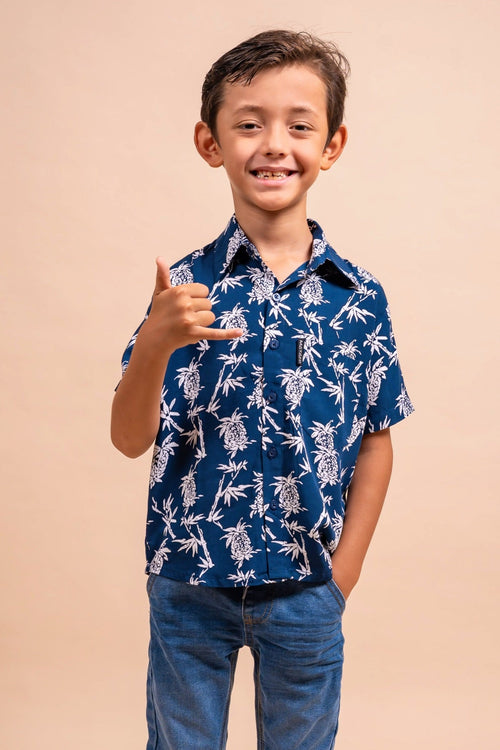 Boy wearing a bleu marine polynesian shirt with pinaeple pattern  