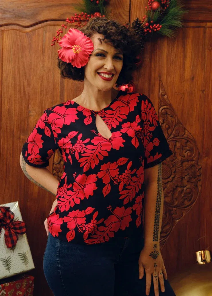 Eimeo Wearing the Maia Shirt in red and Black hibiscus patterns