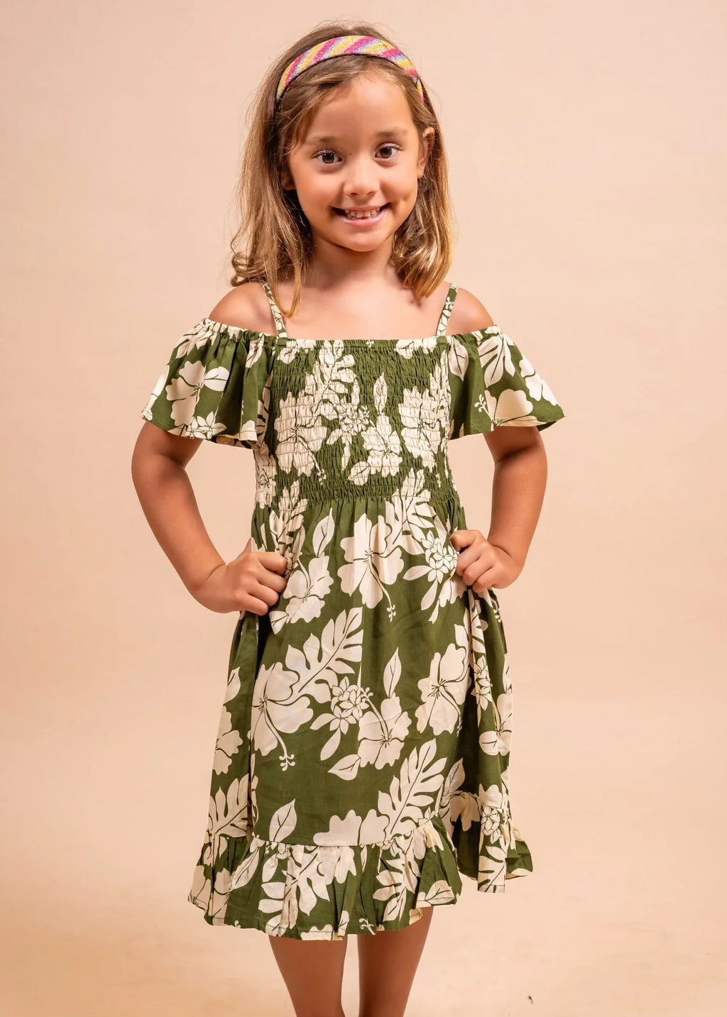 Cute little girl wearing a pareo dress in olive color in flower pattern