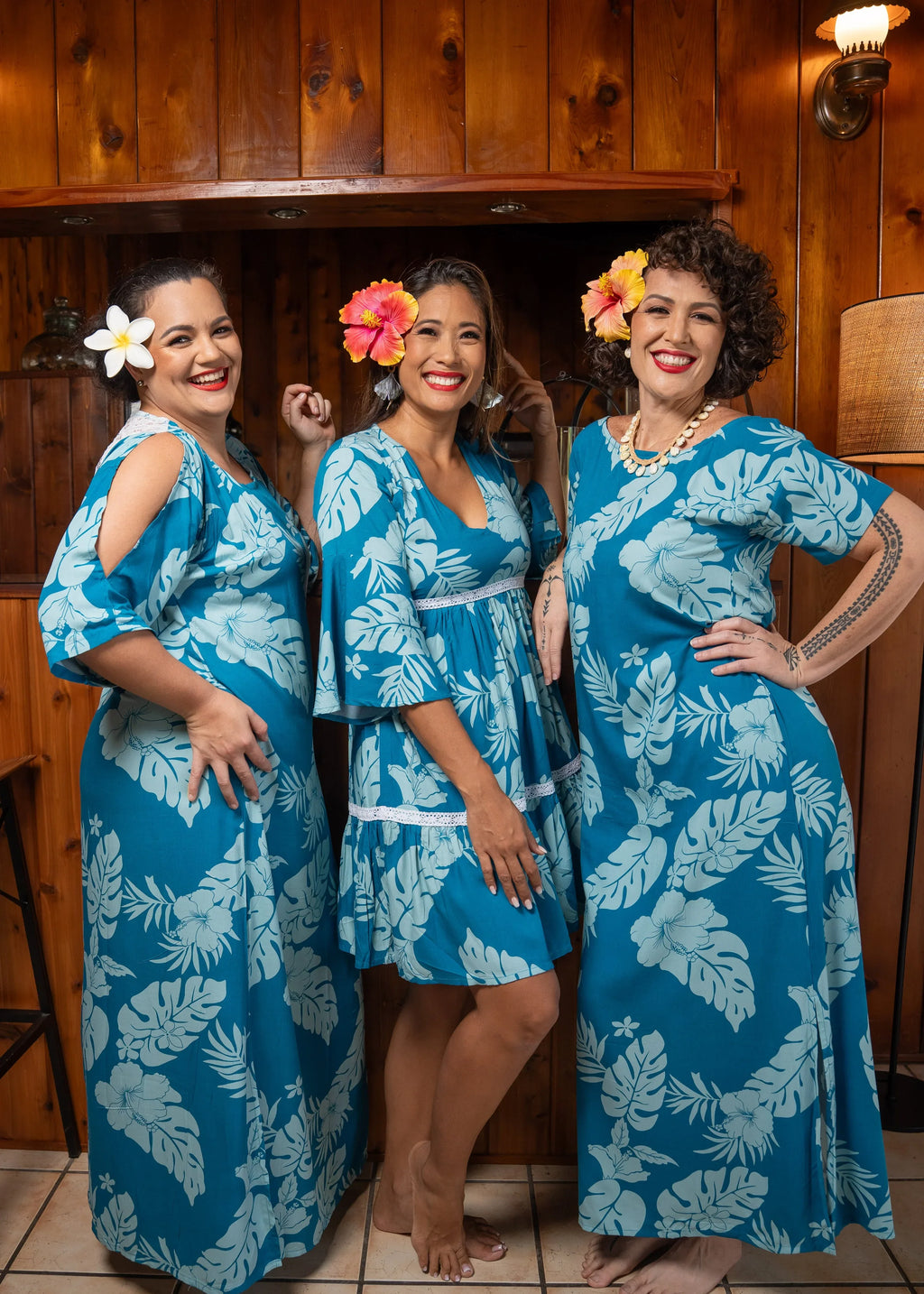 Three Woman wearing Bamboo Kultur’s “Teavei long, Merahi short and Vahine ” blue moana Polynesian dress