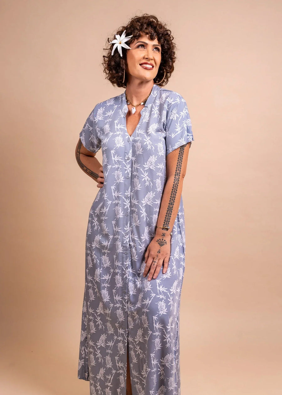 Women with a tiare and polynesian Tattoo wearing a long polynesian dress in grey color with pinaeple pattern
