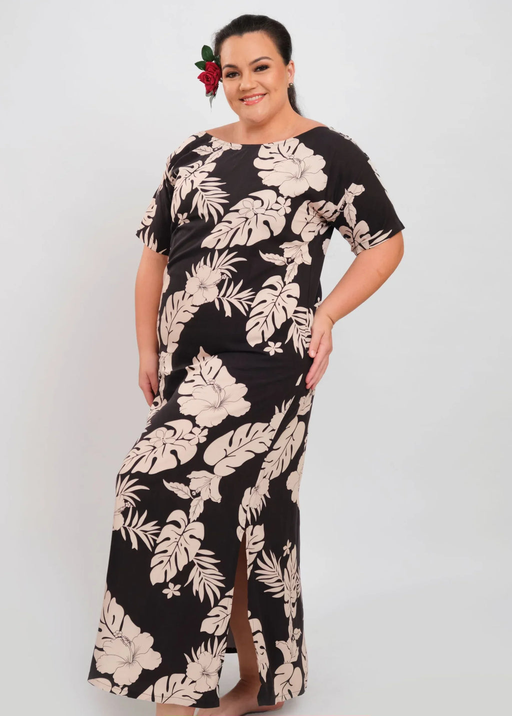 Women with a beautiful red rose on her ear wearing a long polynesian dress in dark and beige color with hibiscus pattern