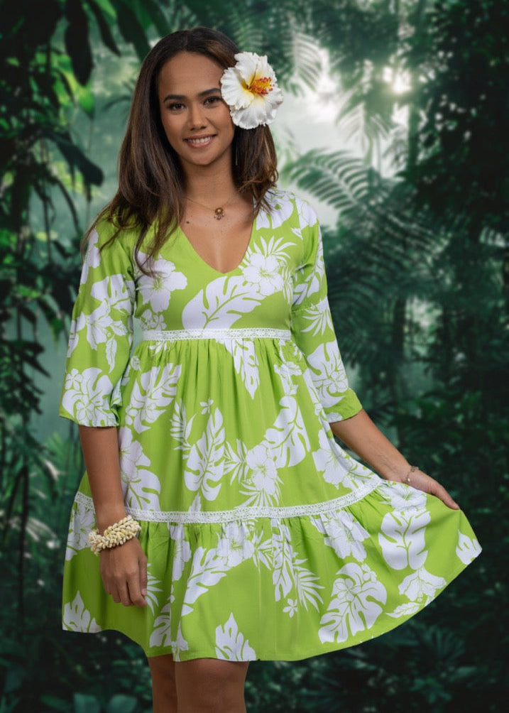 Women wearing Bamboo Kultur’s “Merahi” green floral Polynesian dress,  in the short version, with a hibiscus flower on ear